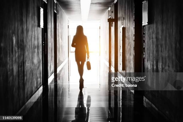 geschäftsfrau durch den bürokorridor - leaving stock-fotos und bilder