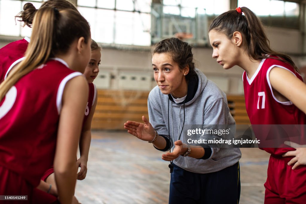 Mooie vrouwelijke coach juichende meisjes voor wedstrijd