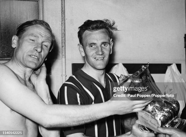 Manchester City footballers Don Revie and Bert Trautmann celebrate with the FA Cup trophy after Manchester City beat Birmingham City 3-1 in the 1956...