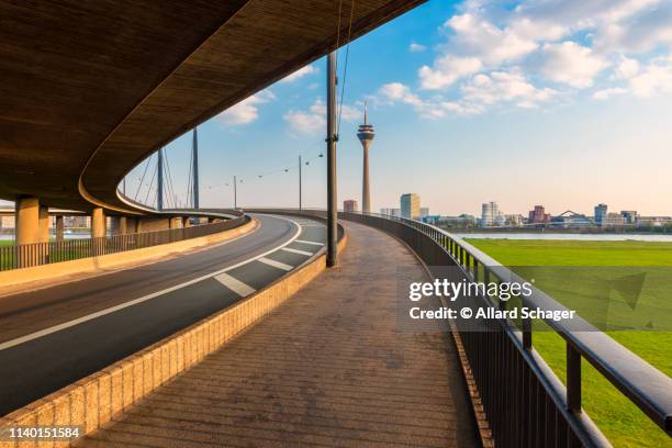 düsseldorf germany skyline as seen from a bridge ramp across the rhine river - düsseldorf skyline stock-fotos und bilder