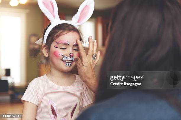 kleines mädchen mit einem kaninchen malerei gesicht - face paint stock-fotos und bilder
