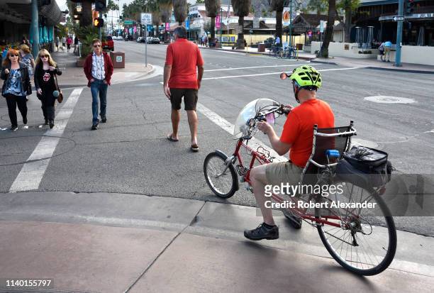 Man rides a Tour Easy recumbent bicycle along a street in Palm Springs, California.
