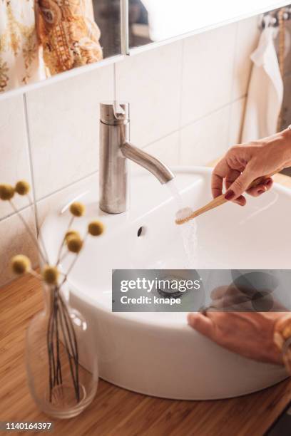 woman brushing teeth with eco friendly wooden toothbrush - toothbrush stock pictures, royalty-free photos & images