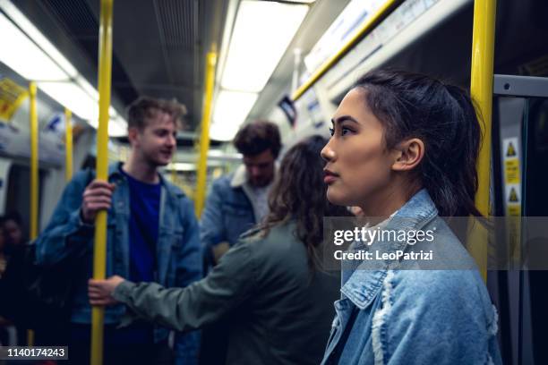 grupo de amigos en el tren de metro - underground london fotografías e imágenes de stock