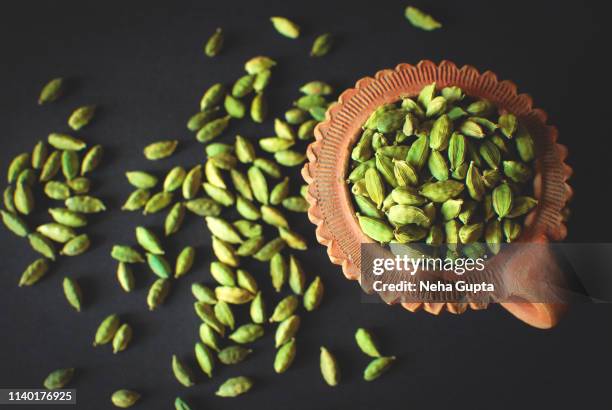 green cardamom in a clay container - cardamom stock-fotos und bilder