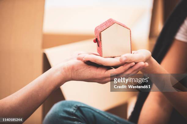 close-up of couple holding tiny house model - hausmodell stock-fotos und bilder