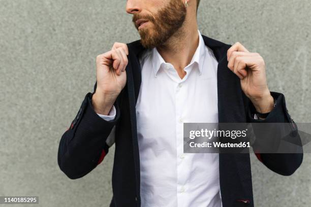 stylish businessman adjusting the collar of his sports jacket - white blazer stock-fotos und bilder