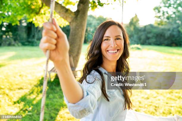 portrait of happy mature woman in garden - older woman with brown hair foto e immagini stock
