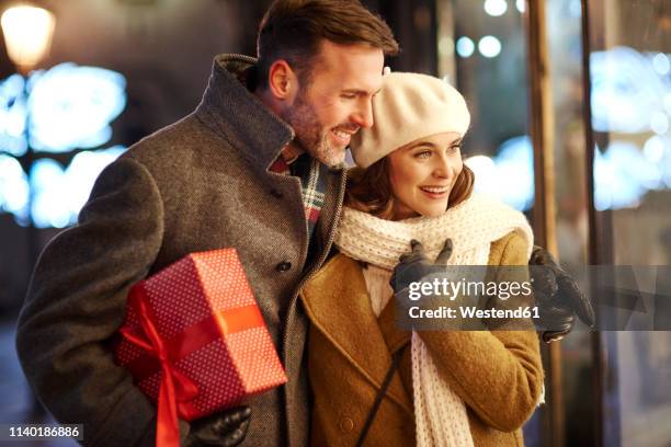 happy couple looking in shop window at christmas time - window shopping stock pictures, royalty-free photos & images