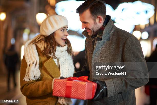 man giving gift to his amazed girlfriend - gift lounge stock pictures, royalty-free photos & images