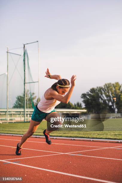 female runner on tartan track starting - tartanbahn stock-fotos und bilder