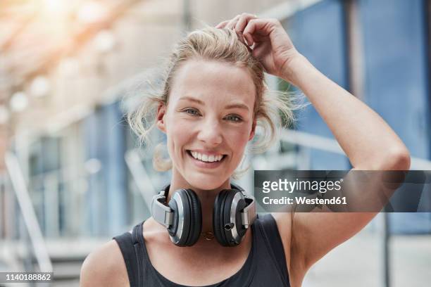 portrait of smiling young woman with headphones - young woman workout stockfoto's en -beelden