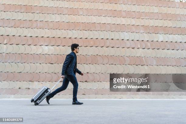 running young businessman with rolling suitcase - necktie run stockfoto's en -beelden