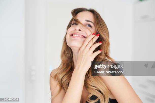 happy young woman playing with her hair - hand in hair stock pictures, royalty-free photos & images