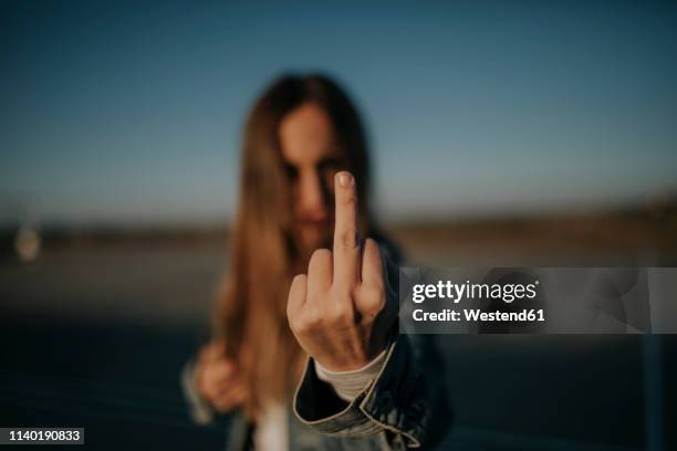 close-up of young woman outdoors giving the finger - doigt dhonneur stockfoto's en -beelden