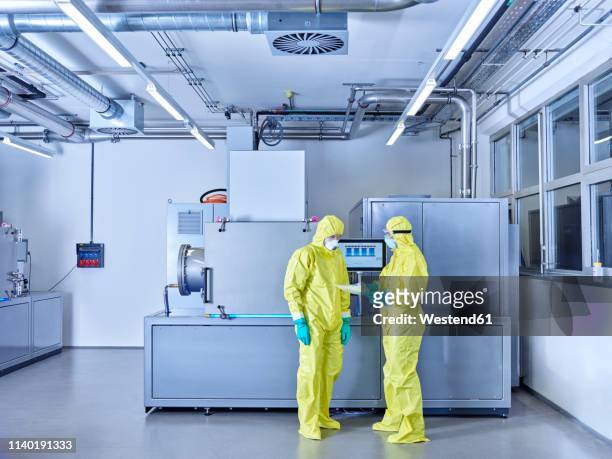 chemists working in industrial laboratory, wearing protective clothing in the clean room - chimiste photos et images de collection