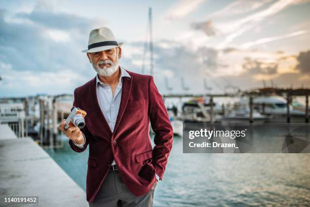 senior latino tourist traveling to sea side and using camera - hat and suit stock pictures, royalty-free photos & images