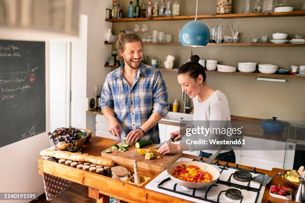 young couple preparing food together, tasting spaghetti - essen zubereiten stock-fotos und bilder