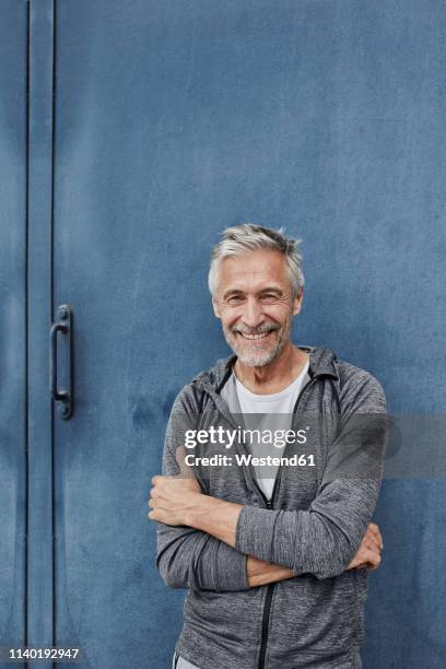 portrait of laughing mature man standing in front of gym - gym entrance exterior stockfoto's en -beelden
