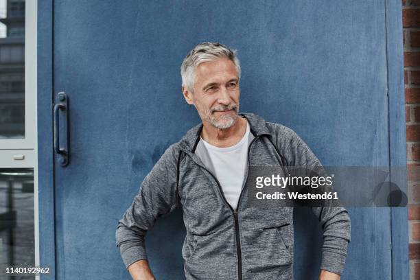 portrait of mature man wearing tracksuit top in front of gym - tracksuit stock pictures, royalty-free photos & images
