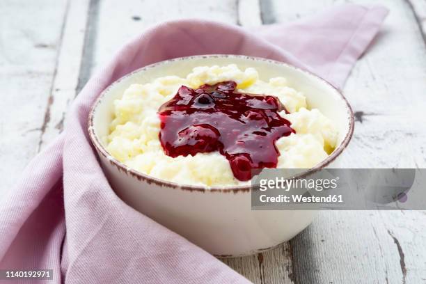 bowl of rice pudding with cherry and berry groats - milchreis stock-fotos und bilder
