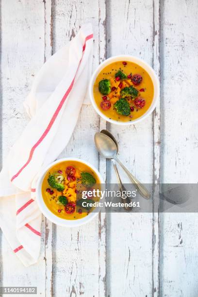 curry dish with pumpkin, sweet potato, brokkoli, tomato, pomegranate seeds and black sesame in bowl - brokkoli stock pictures, royalty-free photos & images
