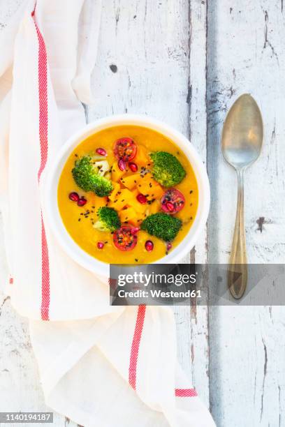 curry dish with pumpkin, sweet potato, brokkoli, tomato, pomegranate seeds and black sesame in bowl - brokkoli stock pictures, royalty-free photos & images