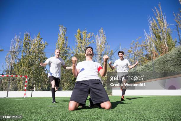 football player celebrating a goal on the grass during a match - blank sports jersey stock pictures, royalty-free photos & images