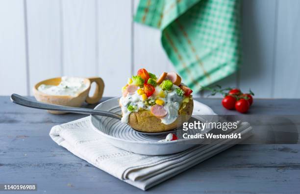baked patato with curd, sausage, vegetables, coen and herbs - gebackene kartoffel stock-fotos und bilder