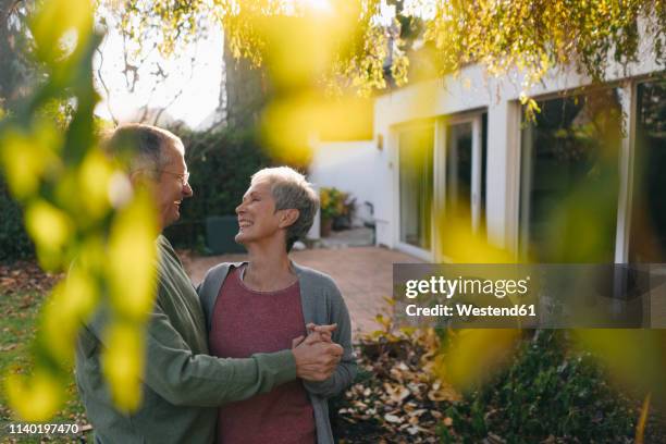 happy affectionate senior couple in garden - aging happy stockfoto's en -beelden