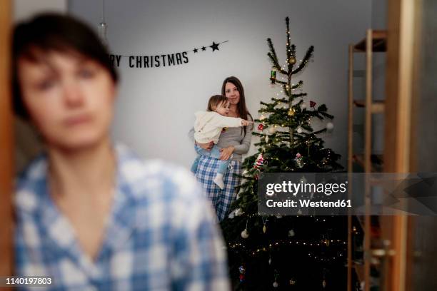 same sex family celebrating christmas at home - same person different outfits stock-fotos und bilder