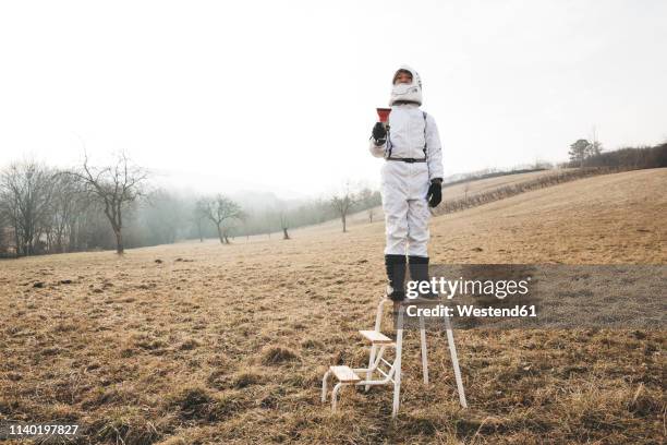 boy wearing white space suit with flashlight on step - alien stock pictures, royalty-free photos & images