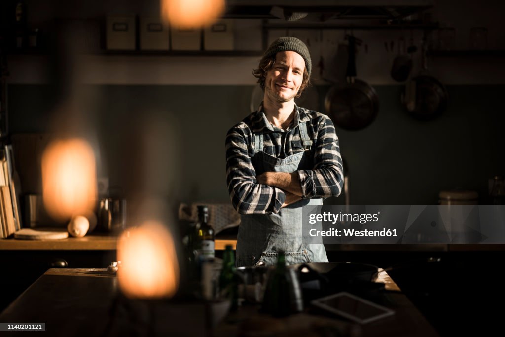 Proud hobby chef standing in his kitchen, with arms crossed