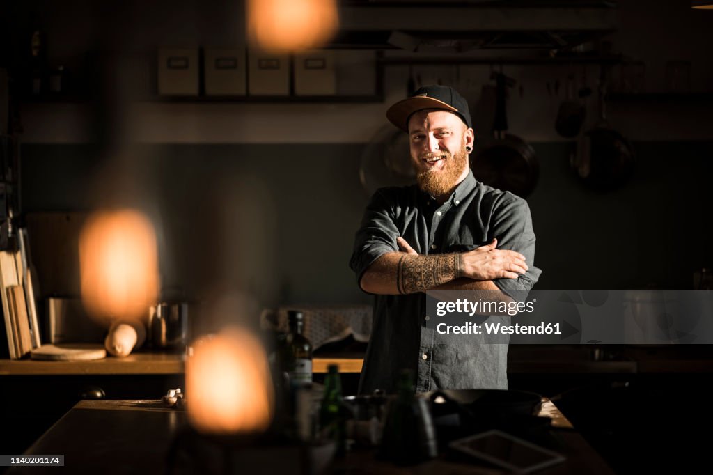 Proud hobby chef standing in his kitchen, with arms crossed