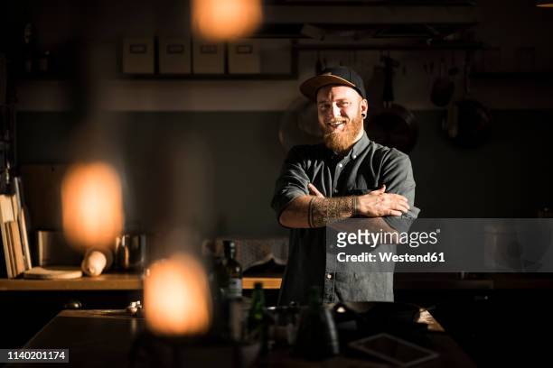 proud hobby chef standing in his kitchen, with arms crossed - pelo facial imagens e fotografias de stock