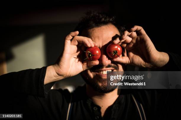 man covering his eyes with tomatoes - funny vegetable stock-fotos und bilder