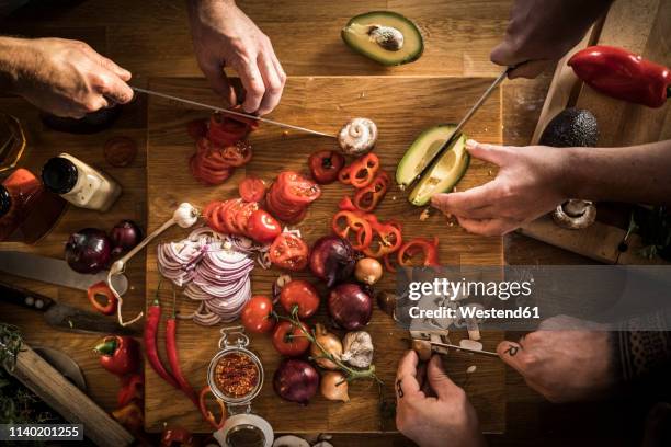 hands chopping vegetables - cooking with friends stock-fotos und bilder