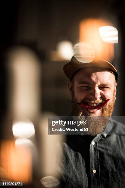 laughing man biting a red chili pod - man mid 20s warm stock pictures, royalty-free photos & images