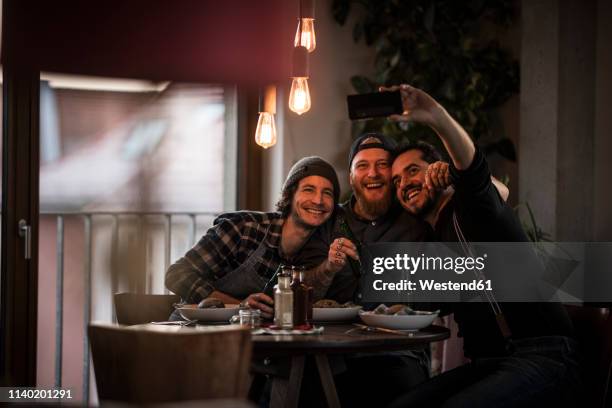 friends eating what they have cooked and taking selfies - hipsters fun indoor stock pictures, royalty-free photos & images