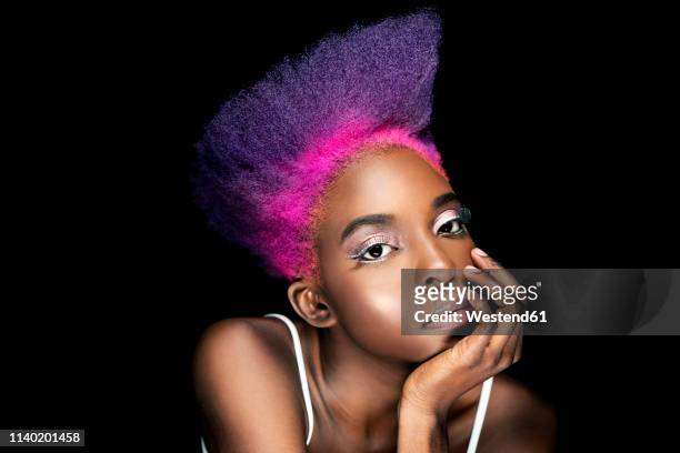 portrait of eccentric young woman with pink and purple dyed hair in front of black background - black hair ストックフォトと画像