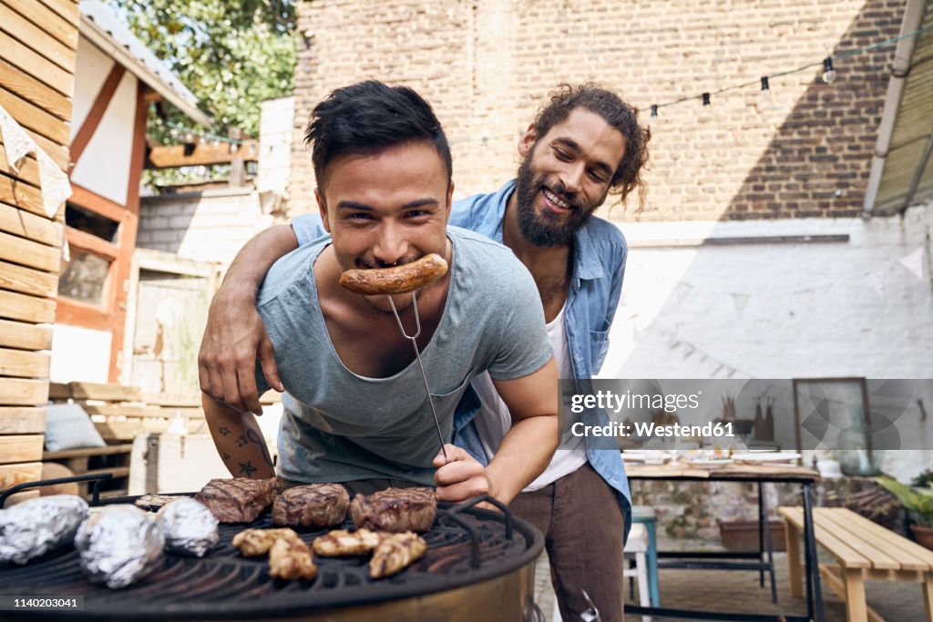 Friends preparing meat for a barbecue in the backyard
