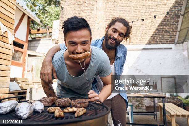 friends preparing meat for a barbecue in the backyard - sausage stock pictures, royalty-free photos & images