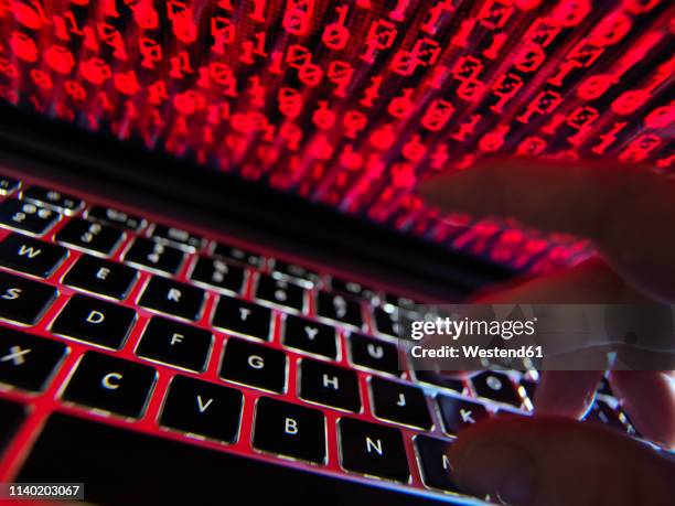 hacker coding a computer virus infecting a laptop - computer virus stock pictures, royalty-free photos & images