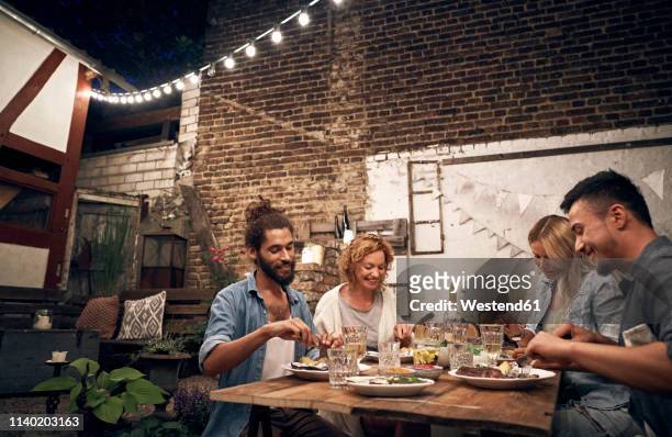 friends having a barbecue in the backyard, eating together - chinese eating backyard stock pictures, royalty-free photos & images