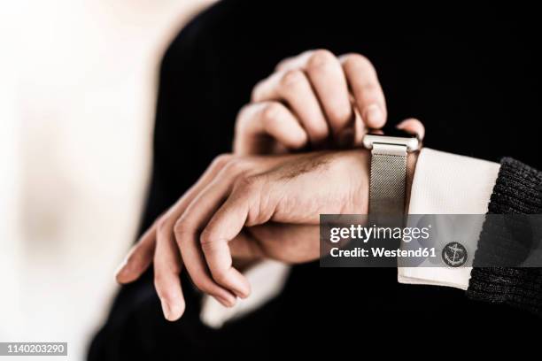 businessman checking the time on his smartwatch - cufflink fotografías e imágenes de stock