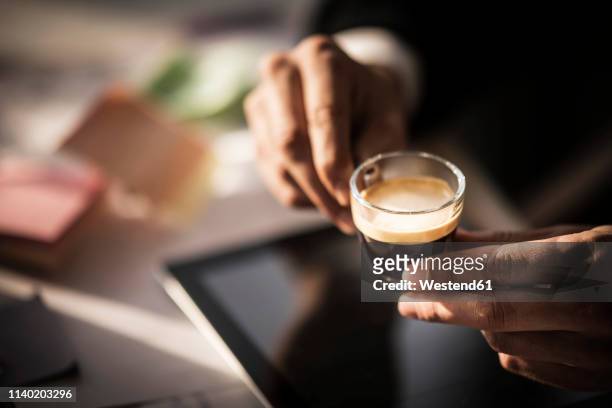 businessman holding cup of coffee in his office - espresso stock pictures, royalty-free photos & images