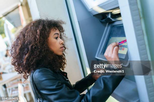 woman using credit card at atm - dab photos et images de collection