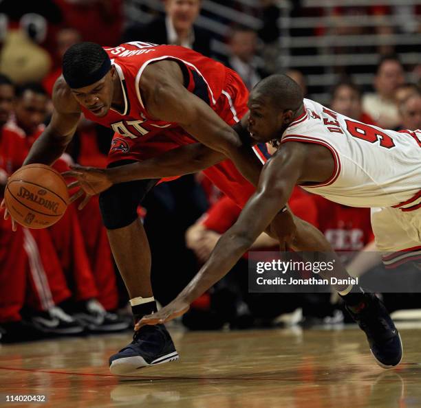 Loul Deng of the Chicago Bulls dives for the ball held by Joe Johnson of the Atlanta Hawks in Game Five of the Eastern Conference Semifinals in the...