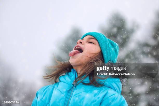 girl looking up, sticking out tongue catching snowflakes - catching snowflakes stock pictures, royalty-free photos & images