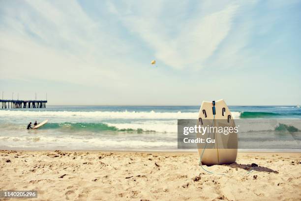 surfboard upright in sand on venice beach, los angeles, california - la beach stock pictures, royalty-free photos & images